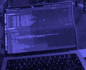 A Macbook Pro, viewed through the monochrome passthrough camera of a Steam Frame. The text in the terminal window is unreadable.