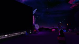 VRChat screenshot, the Linux mascot Tux looks uat a video player with nothing playing, against a starry sky.